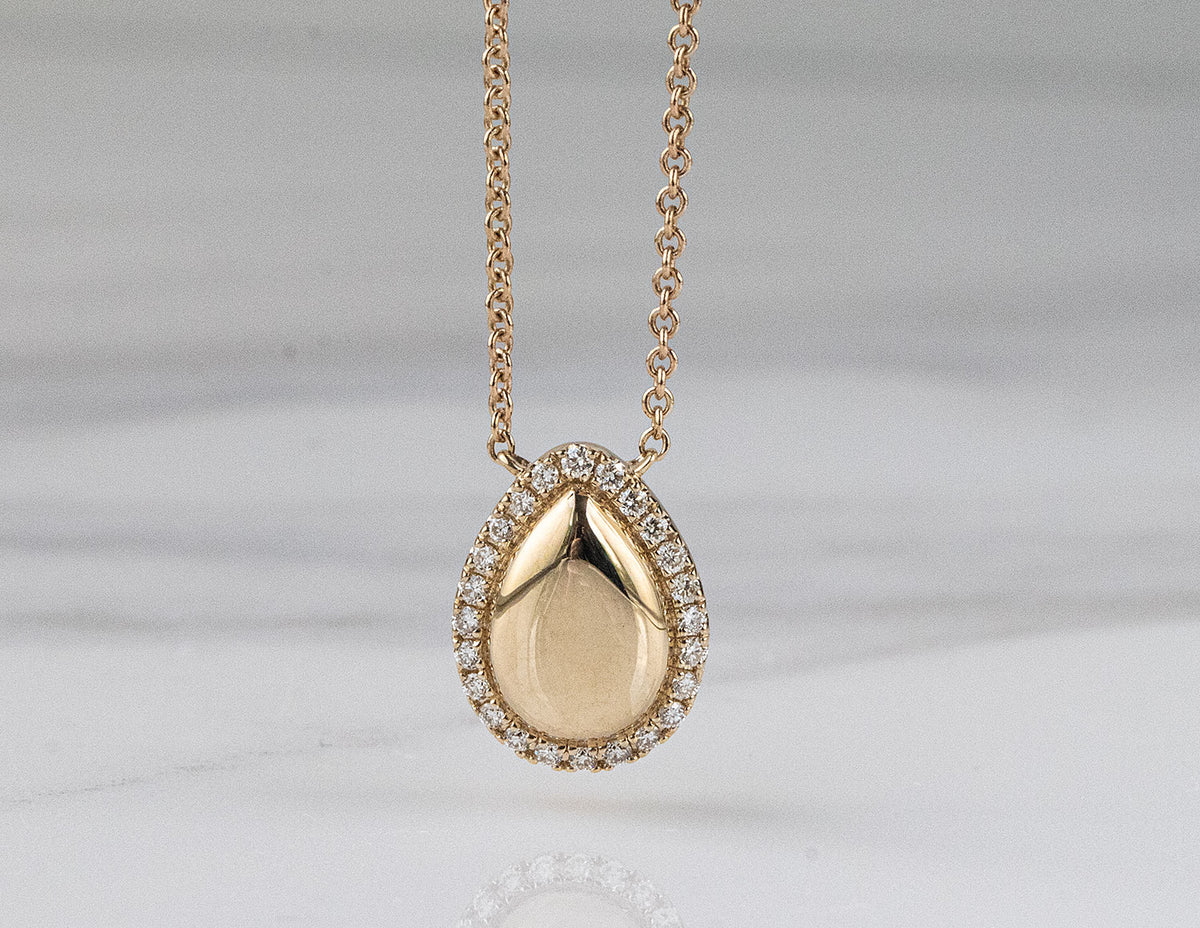 1/10ct. t.w. Pear Shape Diamond Halo Pendant in 14K Yellow Gold